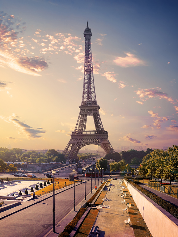 Eiffel Tower in France during a sunset with clouds in the background.