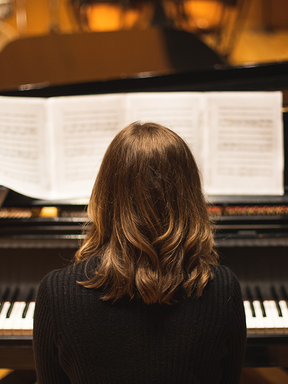 music student playing a piano in the Music Hall at the Center for Fine and Performing Arts