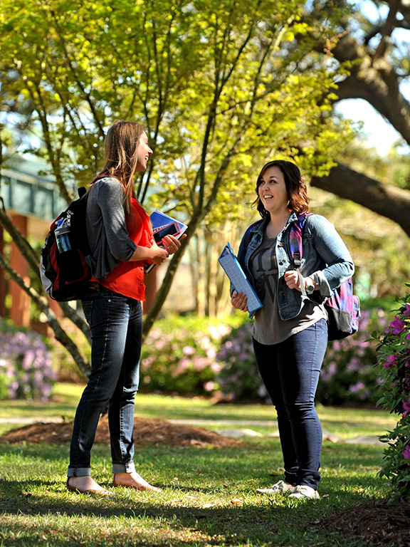 two students conversing outside on the pensacola campus