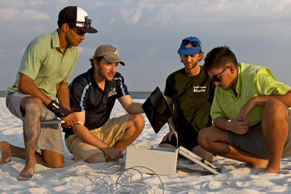 uwf students setting up a weather station at pensacola beach
