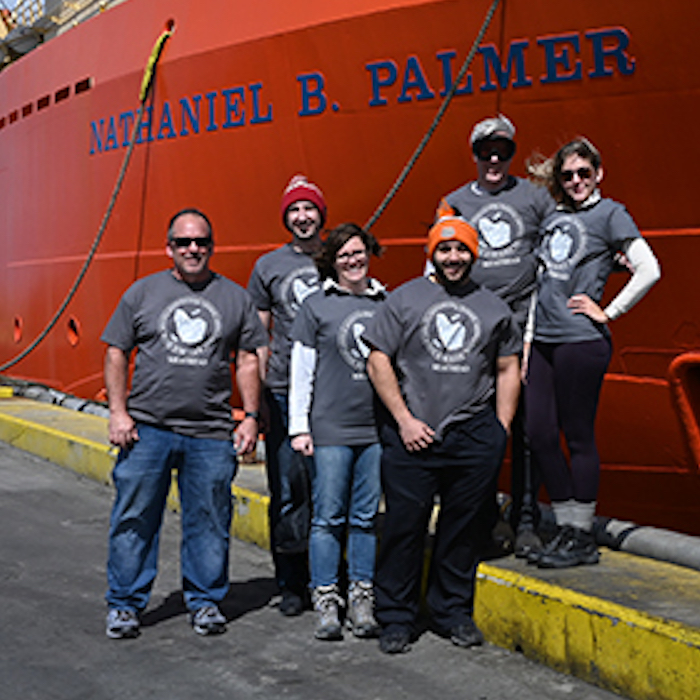 a group of students and professors in front of a research ship