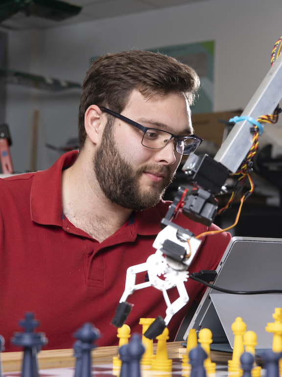engineering student working with a robotic arm