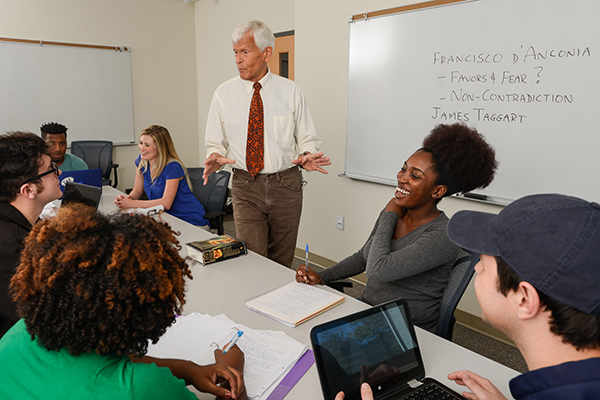 Dr. Bob Kimball, UWF business professor, discusses free market economies with students from his Professional Selling Methods and Sales Management courses.