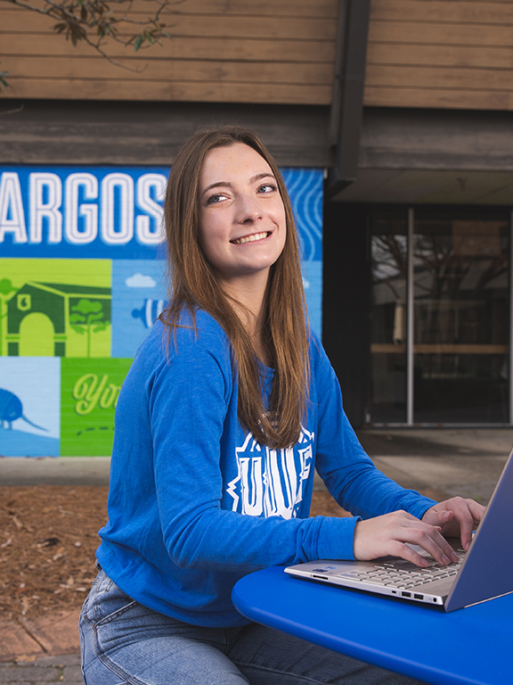 Online student in front of UWF Argo Commons banner