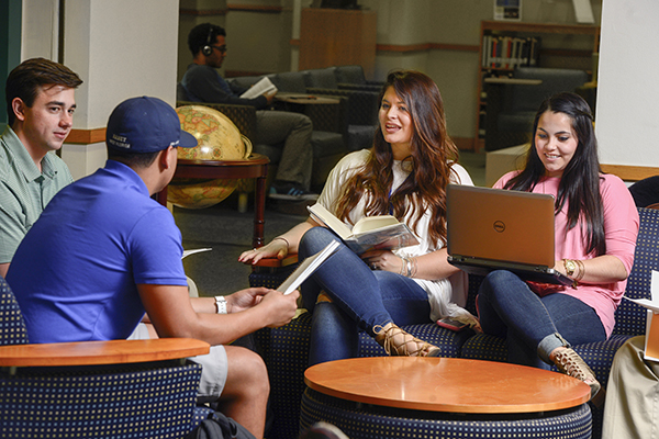 Four students studying as a group in the library.