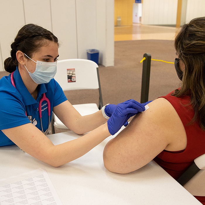 uwf nursing student administering a covid vaccine